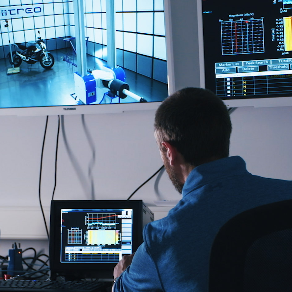 Ein Mensch überwacht die Werte in einem Windkanal am Monitor.