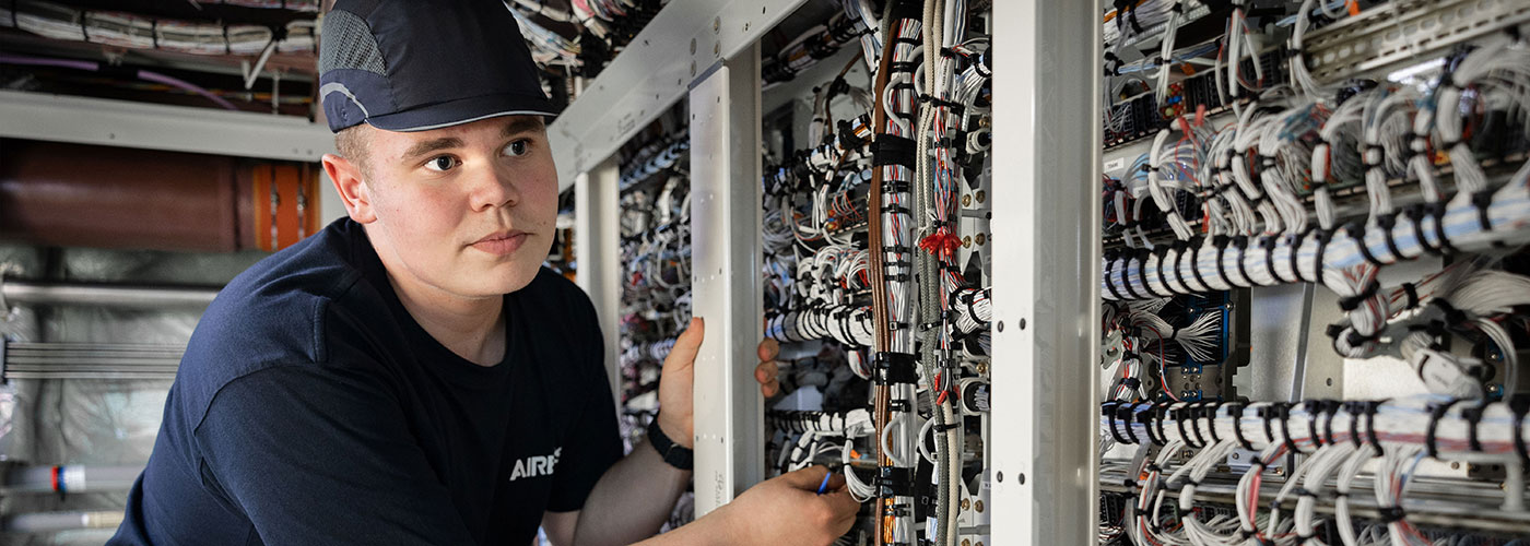 Ein Azubi arbeitet an einem Verteilerkasten bei AIRBUS