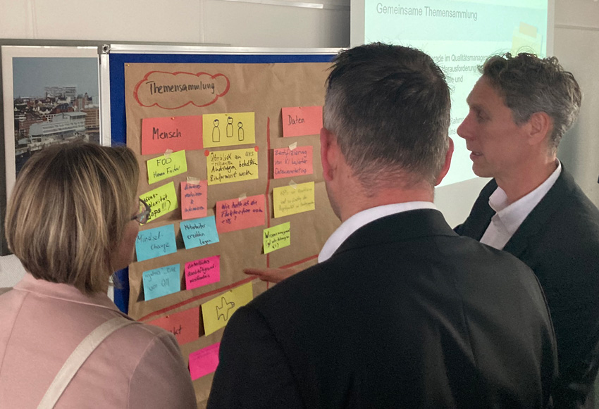 Qualitätsdialog Menschen diskutieren vor einer Pinnwand über Konzepte